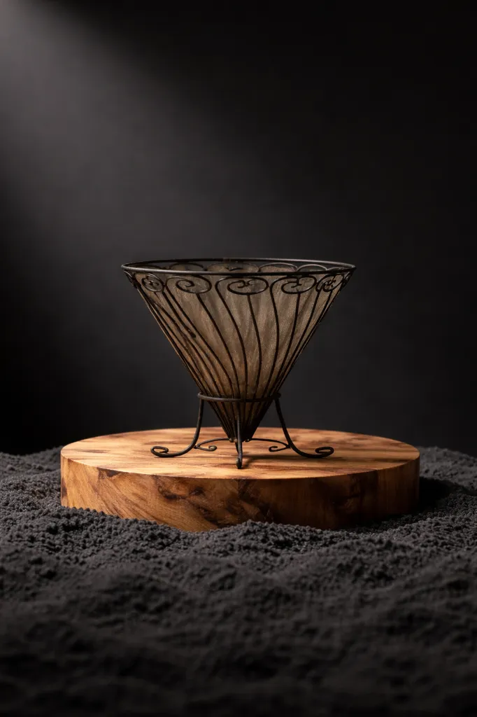 Elegant wire basket on wooden platform.webp