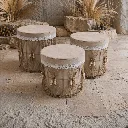Boho-chic stone patio with woven stools.webp