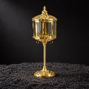 Ornate gold lantern on dark surface.webp