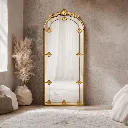 Elegant gold-framed mirror in serene room.webp
