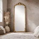 Ornate gold mirror in minimalist room.webp
