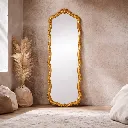 Elegant gold-framed mirror in cozy room.webp