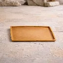 Wooden tray on textured stone floor.webp