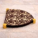 Elegant Art Deco trivet on stone floor.webp